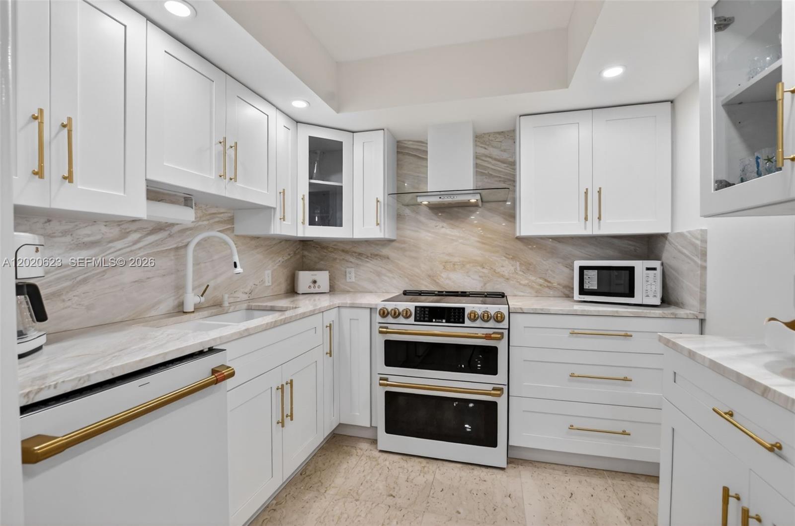 4101 North Ocean Boulevard, Unit 1605 Boca Raton, FL 33431 - Photo 6 of 35 a kitchen with granite countertop white cabinets and stainless steel appliances