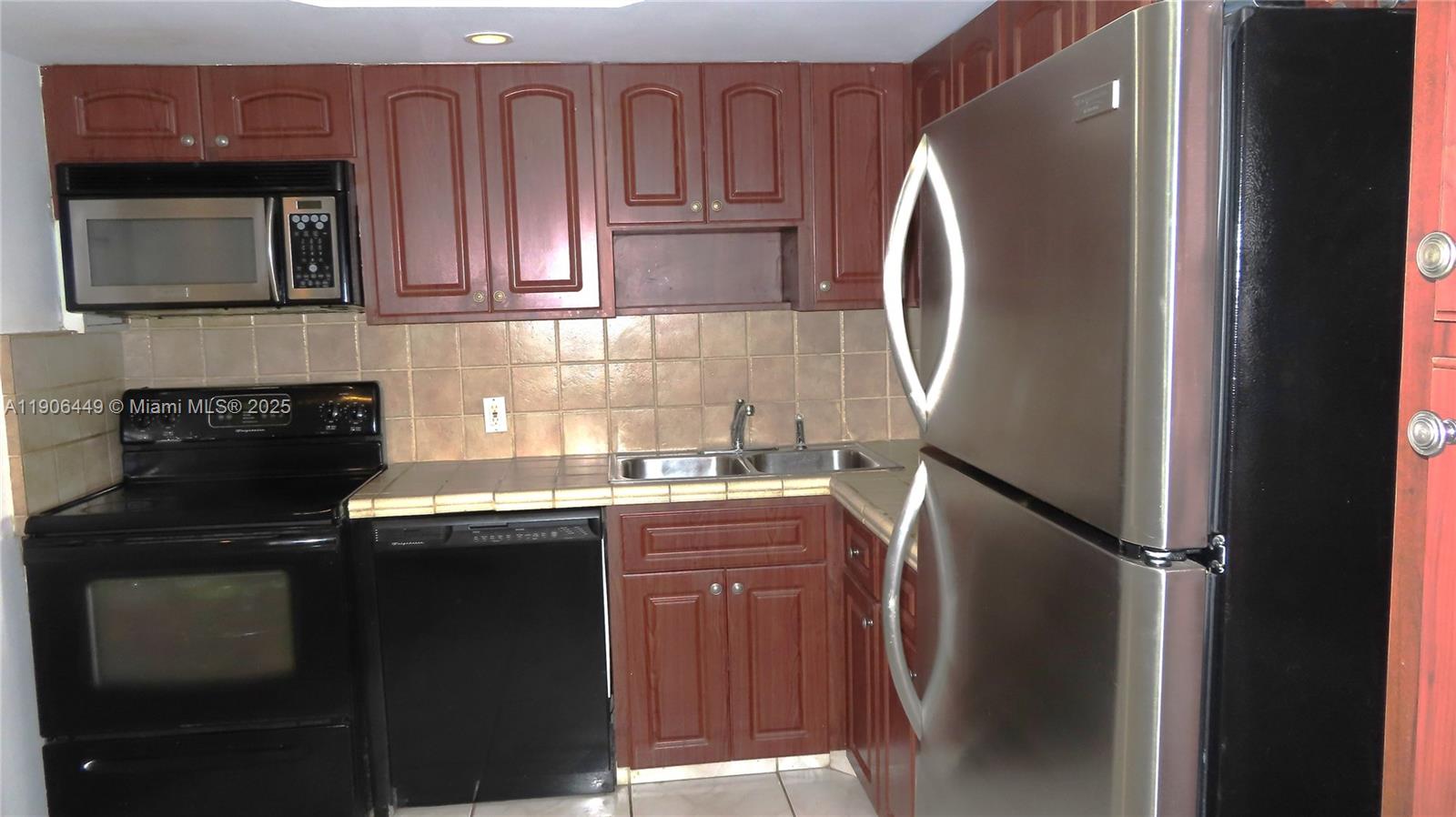 5701 Collins Avenue, Unit 511 Miami Beach, FL 33140 - Photo 10 of 51 a kitchen with stainless steel appliances granite countertop a refrigerator sink and cabinets