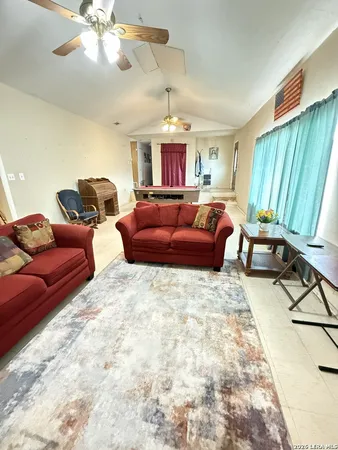 a living room with furniture a chandelier and a flat screen tv