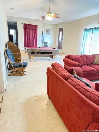 a living room with furniture kitchen view and a window