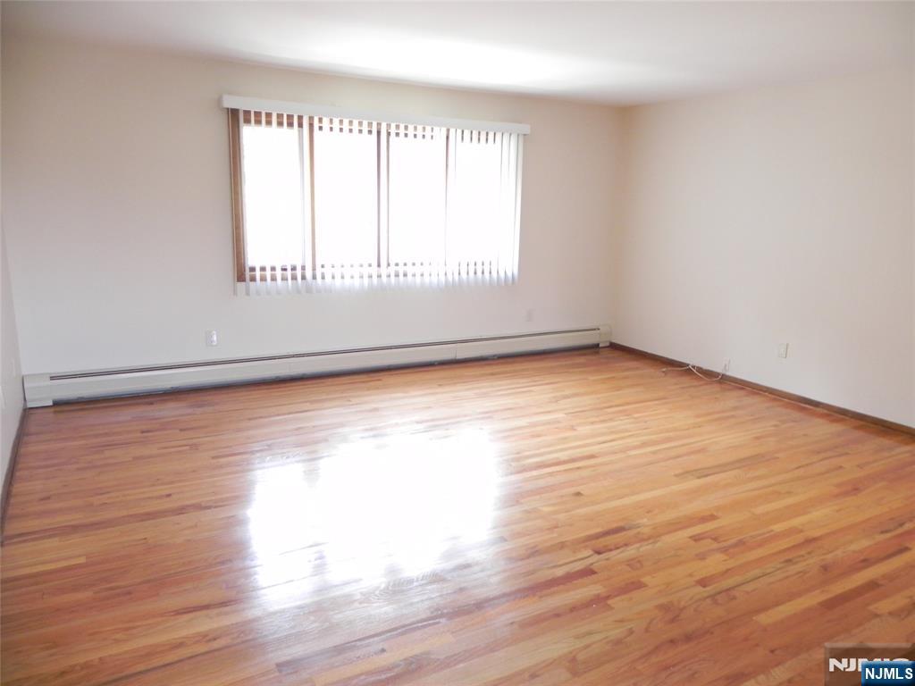 52 Wilson Street, Unit 2 Little Ferry, NJ 07643 - Photo 2 of 11 a view of an empty room with wooden floor and a window
