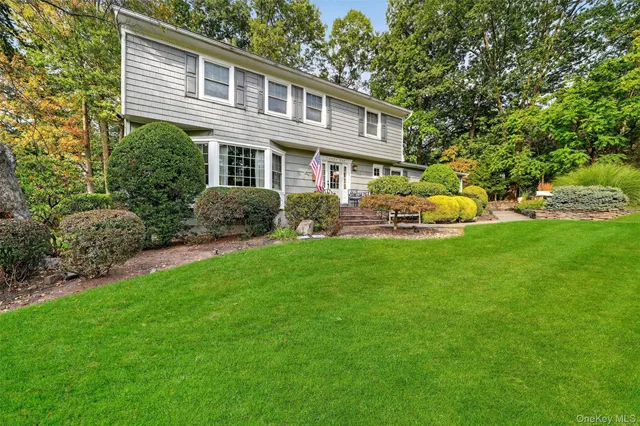 a front view of a house with a yard and trees