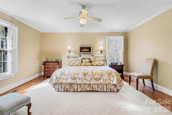 a spacious bedroom with a bed a chandelier and a window