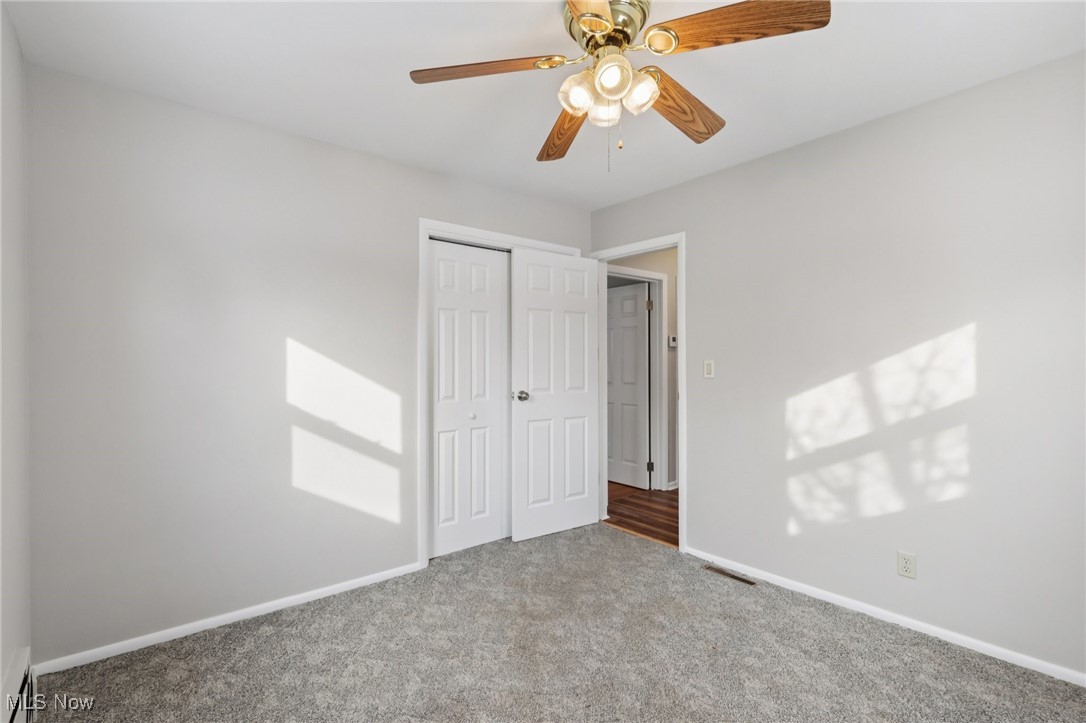 611 Wilson Street Struthers, OH 44471 - Photo 31 of 44 Unfurnished bedroom featuring carpet flooring, a closet, a ceiling fan, and a baseboard heating unit
