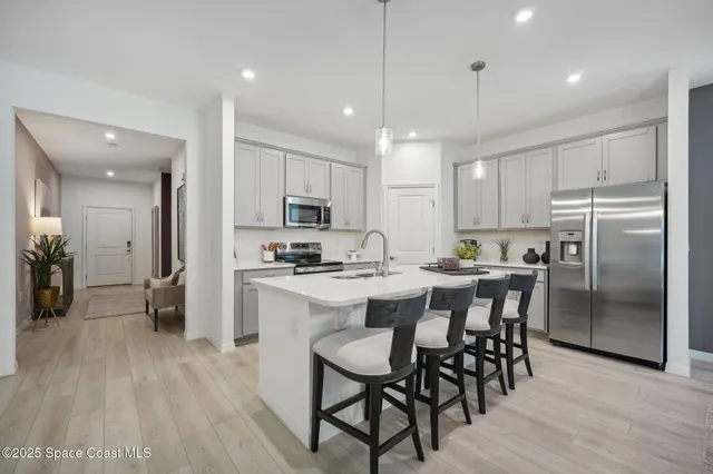 a kitchen with refrigerator a sink and chairs