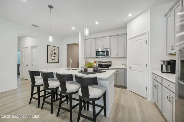 a kitchen with white cabinets and chairs