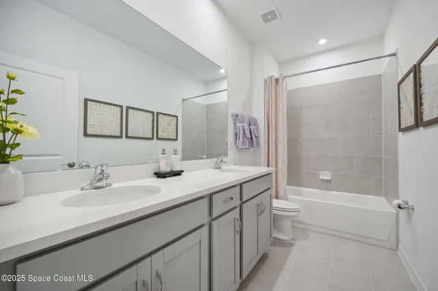 a bathroom with a double vanity sink toilet mirror and bathtub