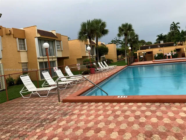 a view of backyard with swimming pool and sitting area