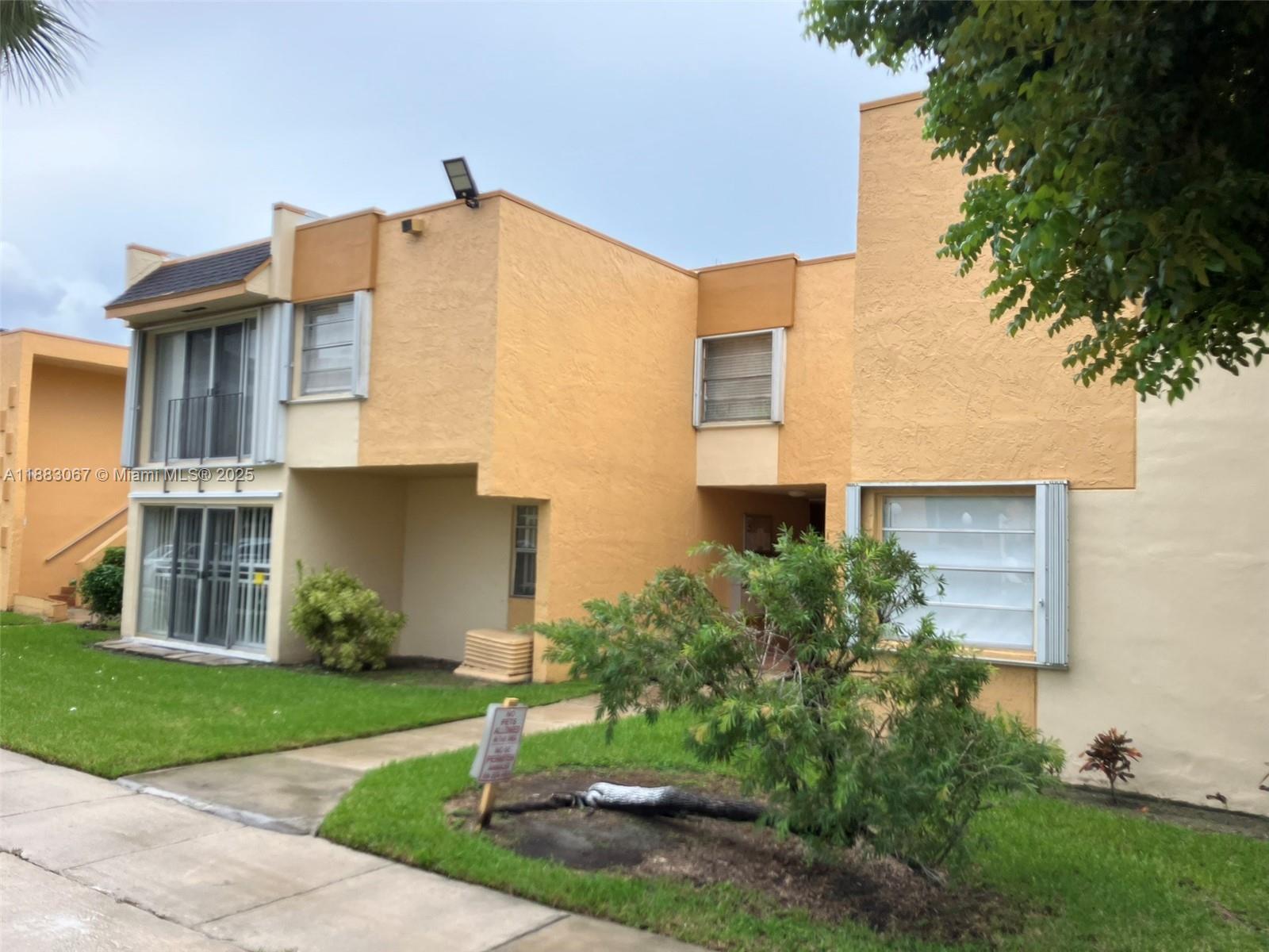 9311 Southwest 4th Street, Unit 104B Miami, FL 33174 - Photo 20 of 21 a front view of a house with a yard