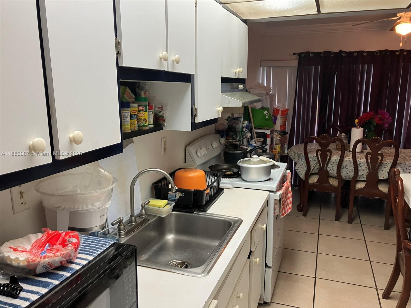 9311 Southwest 4th Street, Unit 104B Miami, FL 33174 - Photo 6 of 21 a kitchen with stainless steel appliances kitchen island granite countertop a sink stove and cabinets