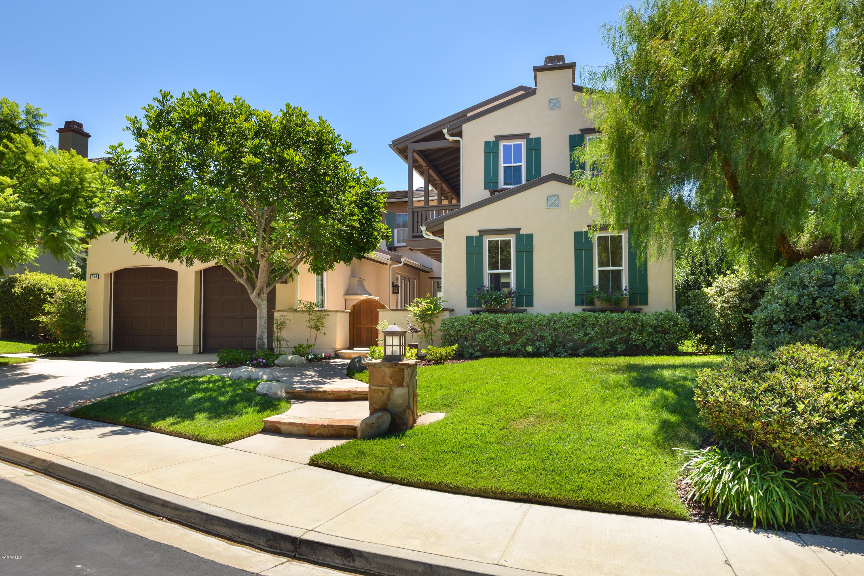 a front view of a house with a yard and potted plants