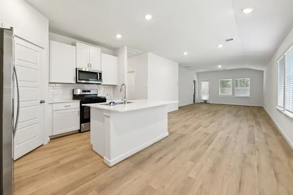 a kitchen with stainless steel appliances a white stove top oven a sink and a refrigerator