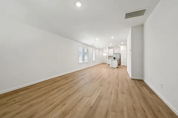 a view of a big room with wooden floor and windows