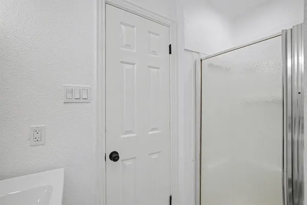a bathroom with a shower and a glass door