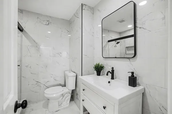 a bathroom with a toilet sink and mirror