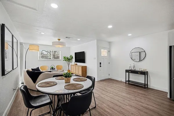 a living room with furniture a flat screen tv and kitchen view