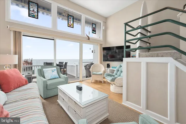 a living room with furniture a large window and white walls