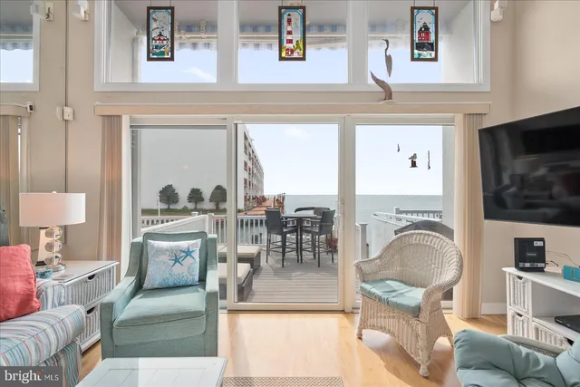 a living room with furniture a flat screen tv and kitchen view