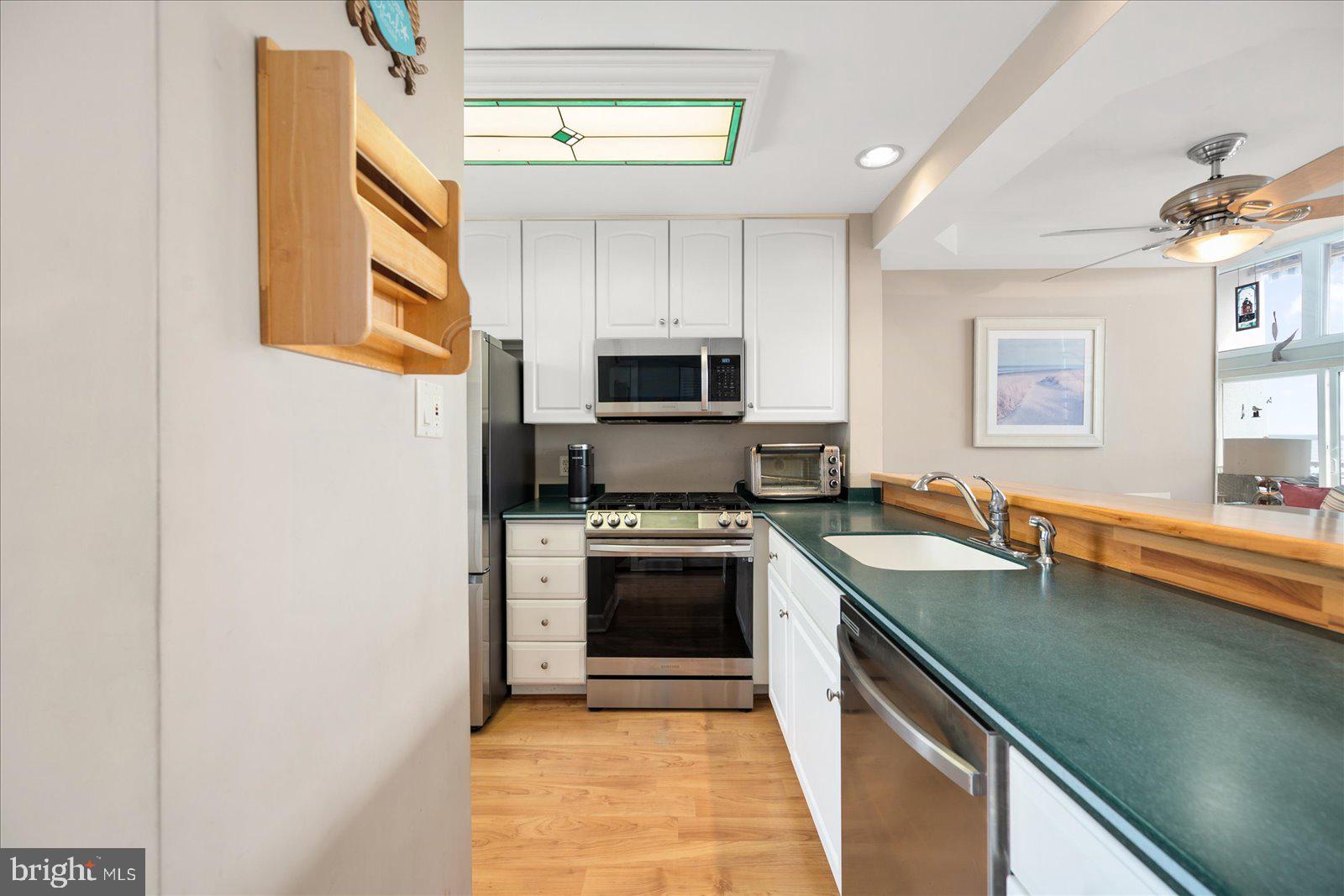 775 94th Street, Unit 775 Ocean City, MD 21842 - Photo 17 of 57 a kitchen with granite countertop a stove top oven and sink