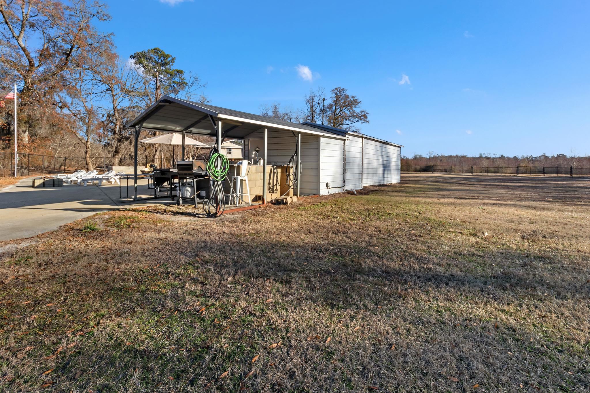 3429 River Road Nichols, SC 29581 - Photo 19 of 26 View of the property featuring fencing, a gazebo and an outbuilding with an outdoor kitchen, bathroom, laundry room and bunk house