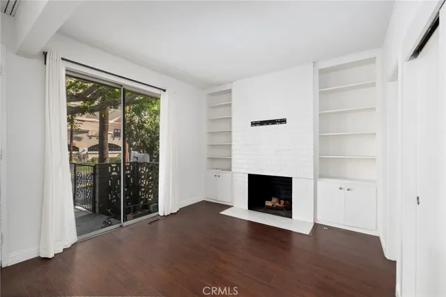 a view of an empty room with a fireplace and a window
