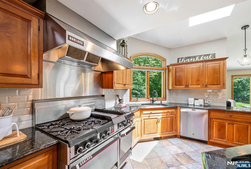 411 Snyder Road Wyckoff, NJ 07481 - Photo 9 of 36 a kitchen with a stove a sink and a microwave