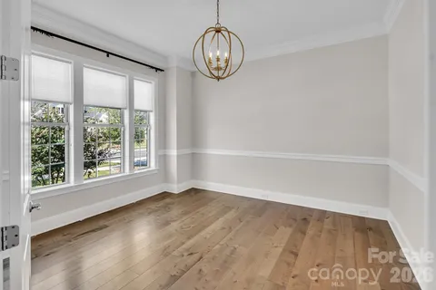 a view of a big room with wooden floor and windows