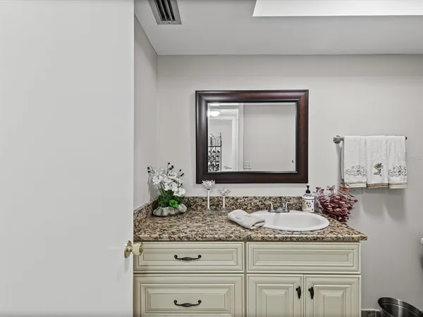 a bathroom with a granite countertop sink and a mirror