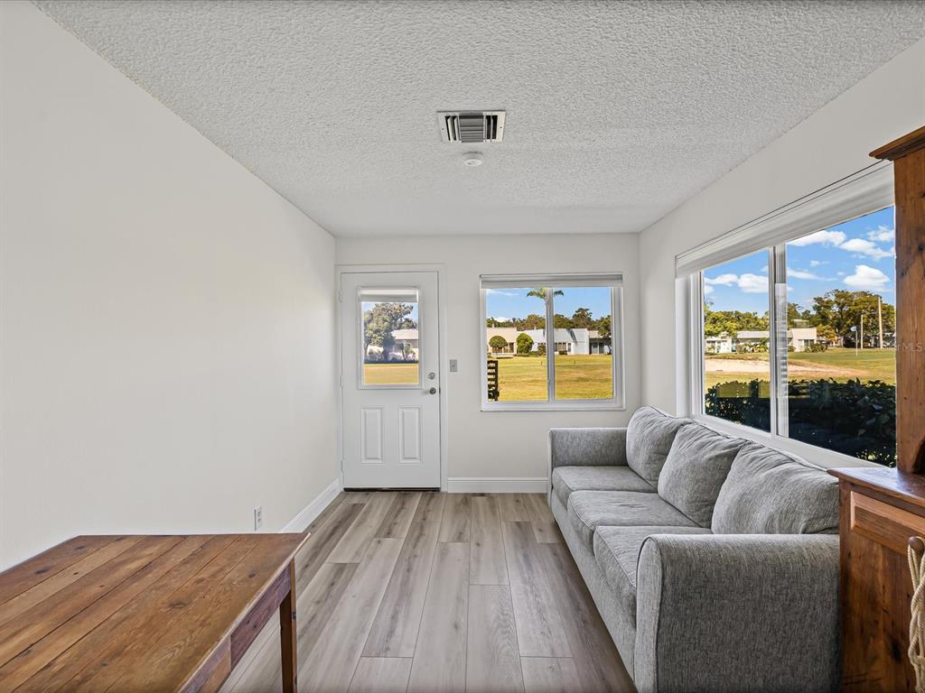 9615 Midiron Court, Unit 9615 New Port Richey, FL 34655 - Photo 26 of 36 a living room with furniture and a floor to ceiling window