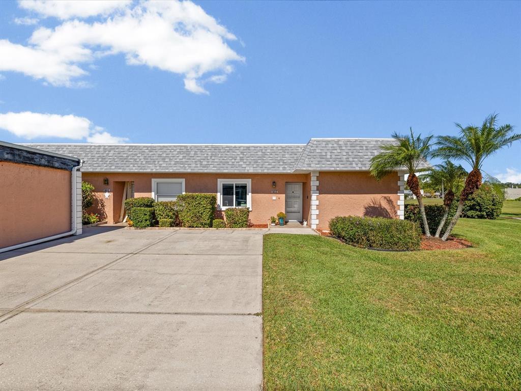 9615 Midiron Court, Unit 9615 New Port Richey, FL 34655 - Photo 30 of 36 a front view of a house with a yard and garage