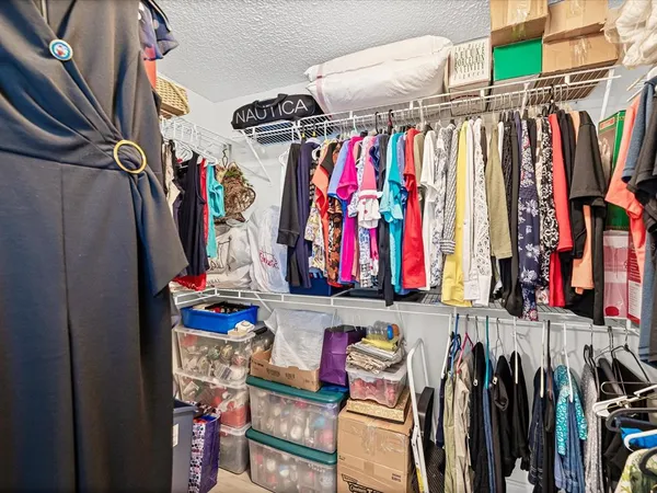 a view of walk in closet with clothes