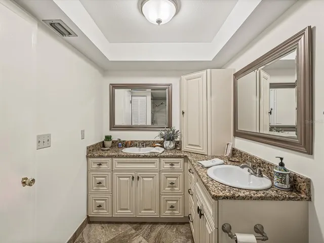 a bathroom with a granite countertop sink and a mirror