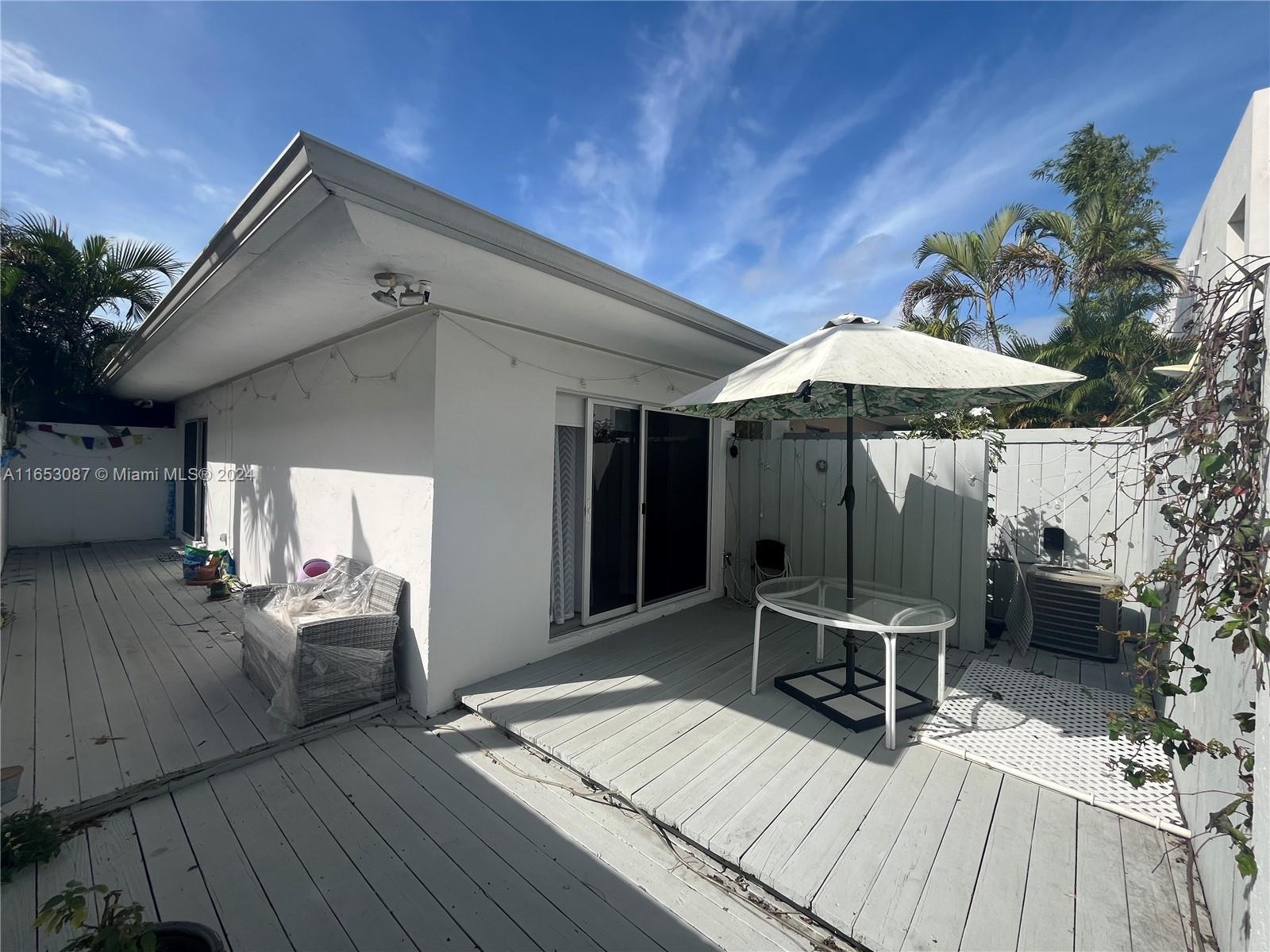 3475 Southwest 1st Avenue, Unit 7 Miami, FL 33145 - Photo 14 of 17 a view of a chairs and table on the wooden floor in front of house