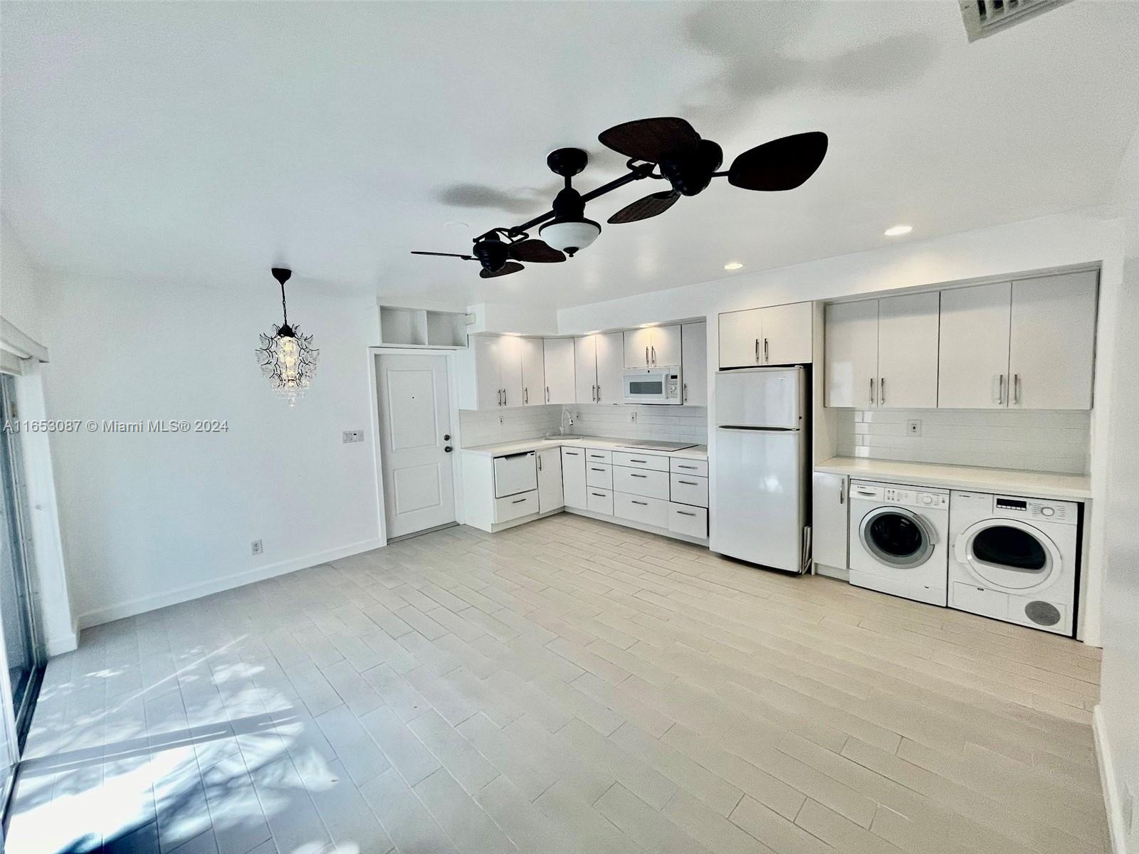 3475 Southwest 1st Avenue, Unit 7 Miami, FL 33145 - Photo 2 of 17 a large kitchen with stainless steel appliances kitchen island granite countertop a refrigerator and a stove top oven