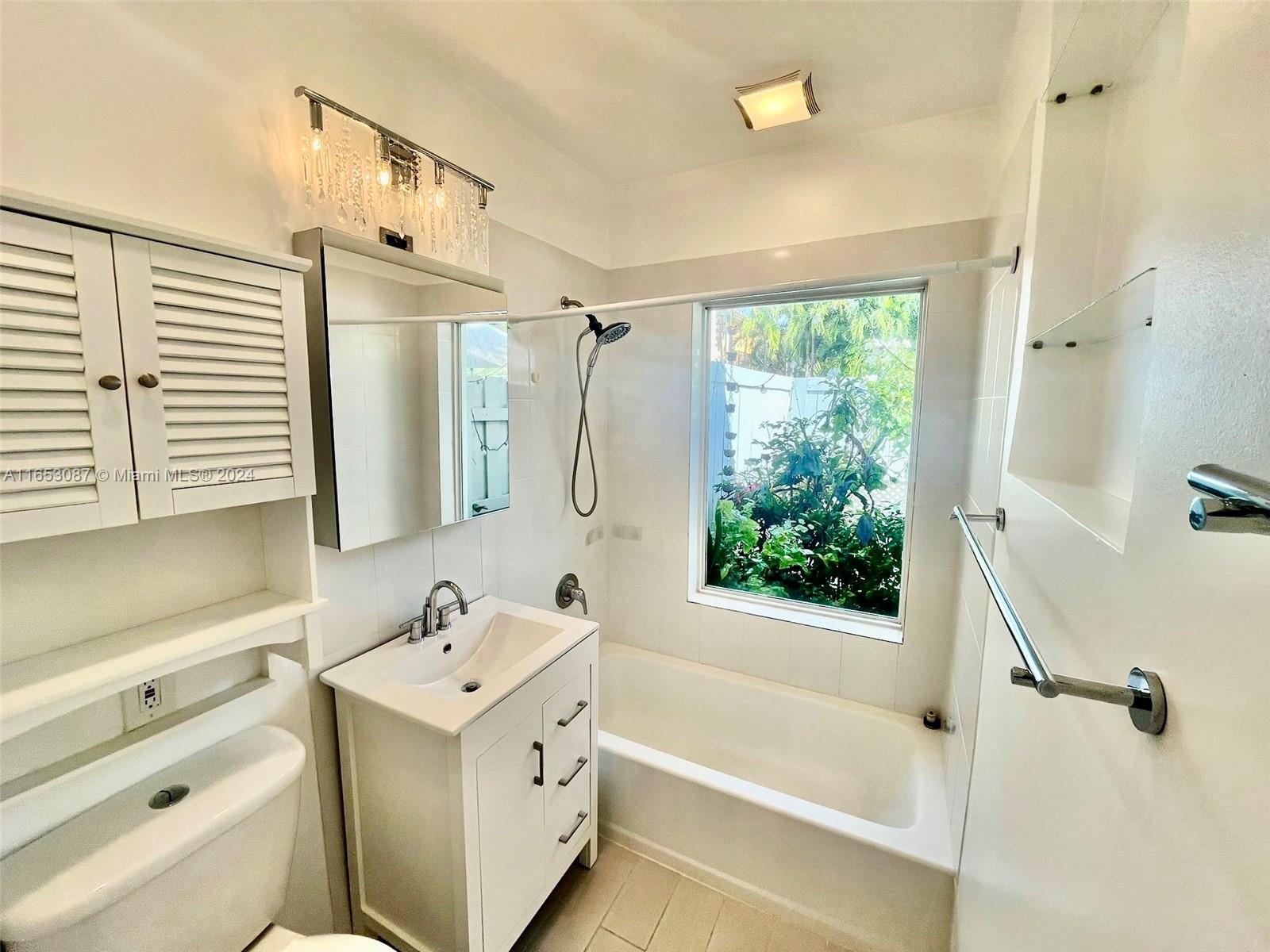 3475 Southwest 1st Avenue, Unit 7 Miami, FL 33145 - Photo 7 of 17 a bathroom with a tub sink and mirror
