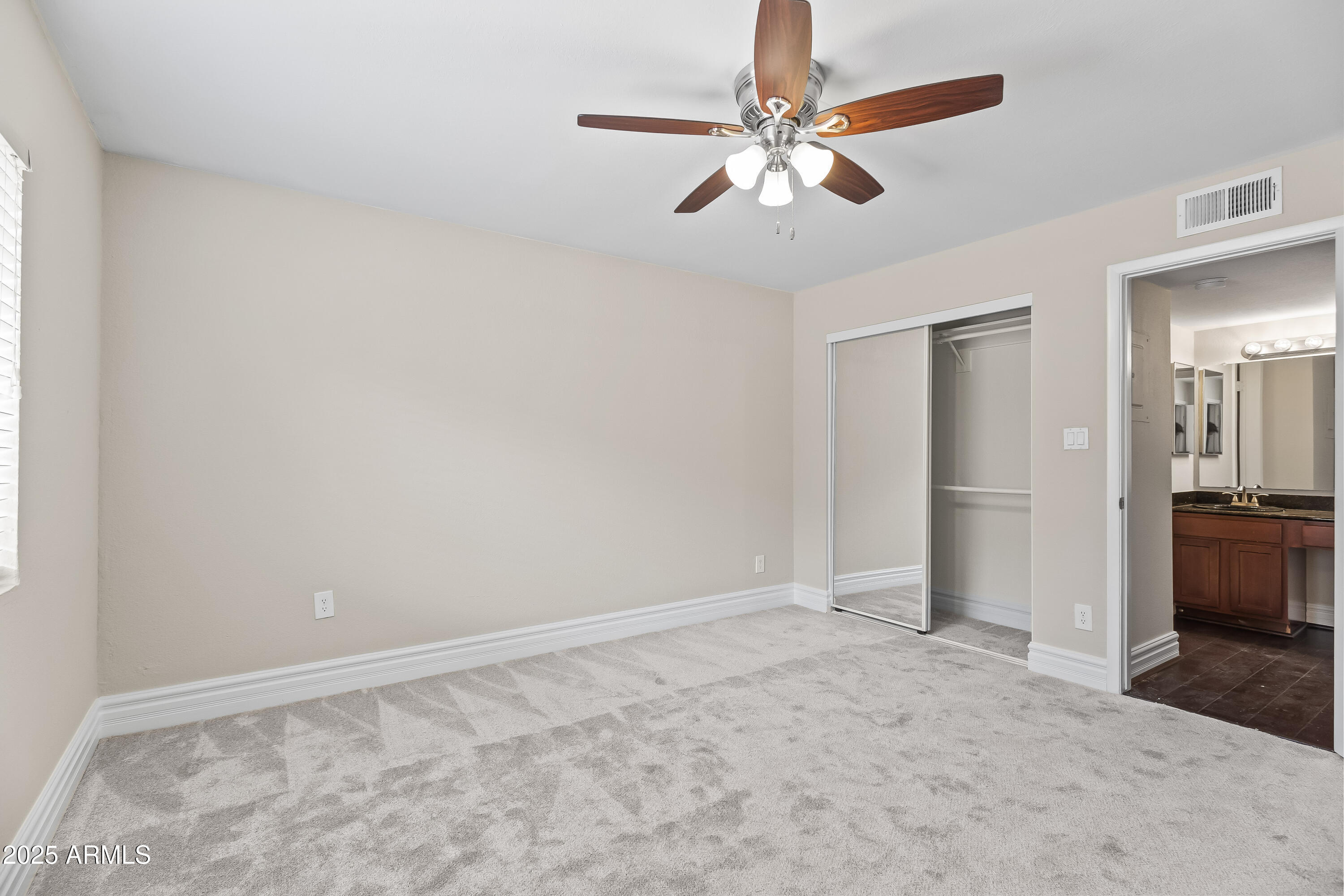 3825 East Camelback Road, Unit 114 Phoenix, AZ 85018 - Photo 8 of 21 an empty room with closet and a chandelier fan