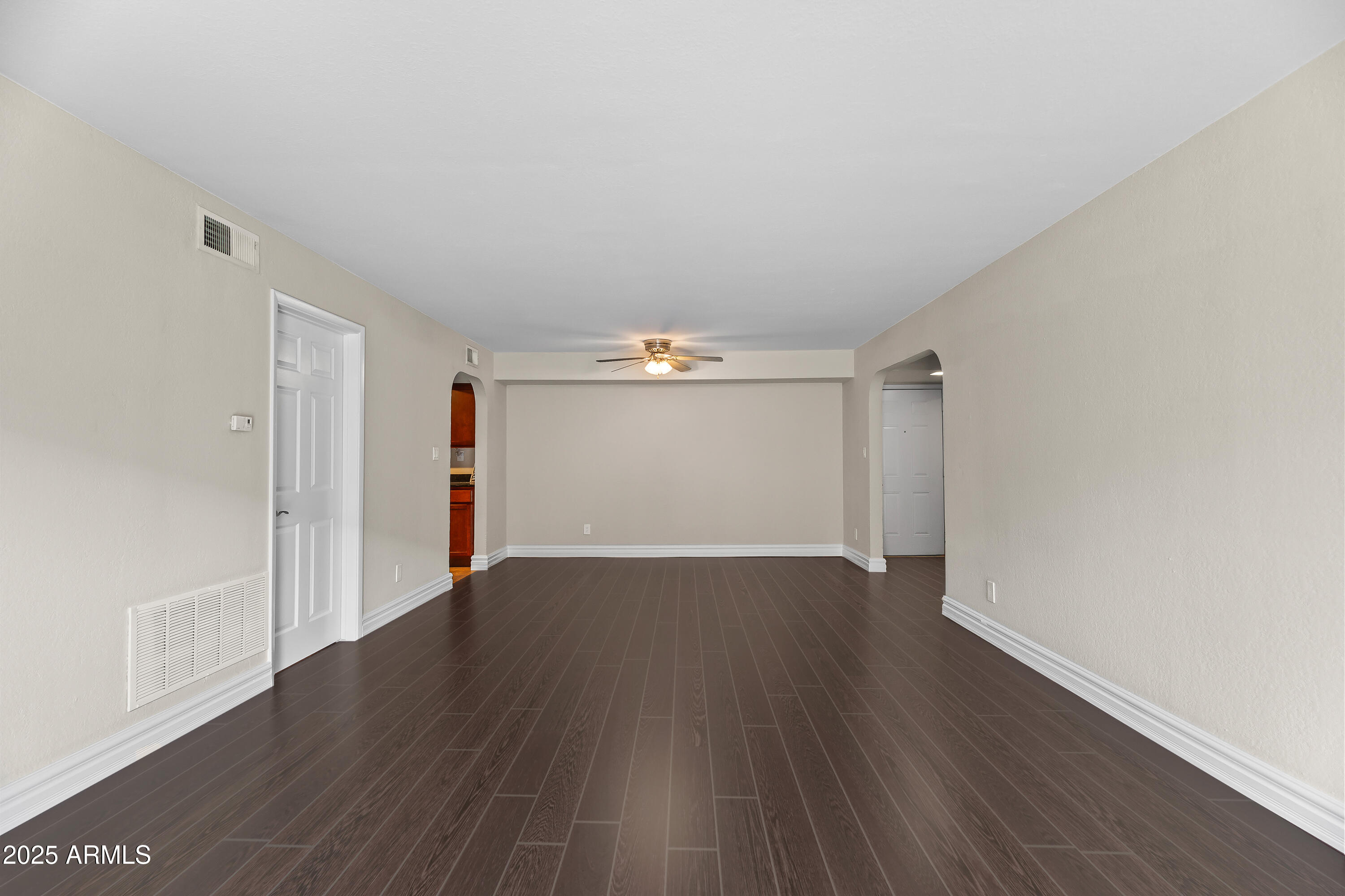 3825 East Camelback Road, Unit 114 Phoenix, AZ 85018 - Photo 10 of 21 an empty room with wooden floor and windows
