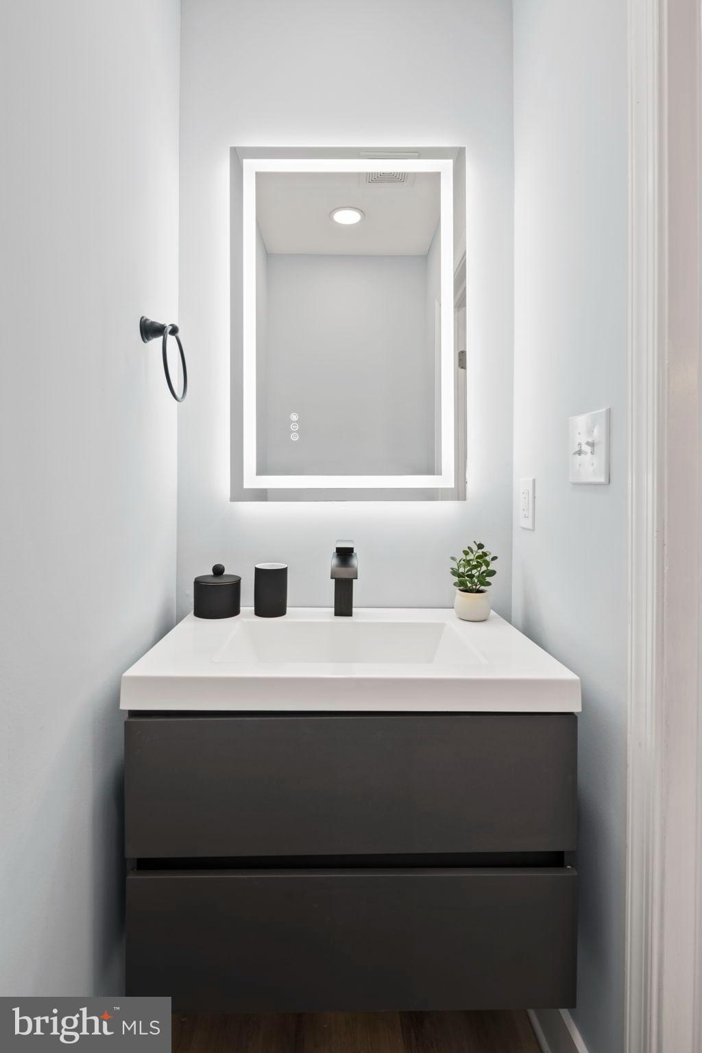 3418 Baker Street Northeast Washington, DC 20019 - Photo 13 of 46 a bathroom with a sink vanity and a mirror