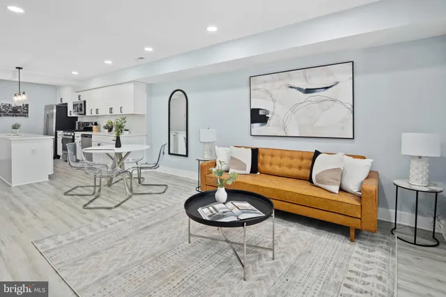 a living room with furniture a rug and kitchen view
