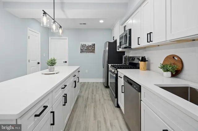 a kitchen with granite countertop a sink stove and cabinets