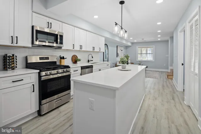 a kitchen with a sink a microwave a stove and refrigerator
