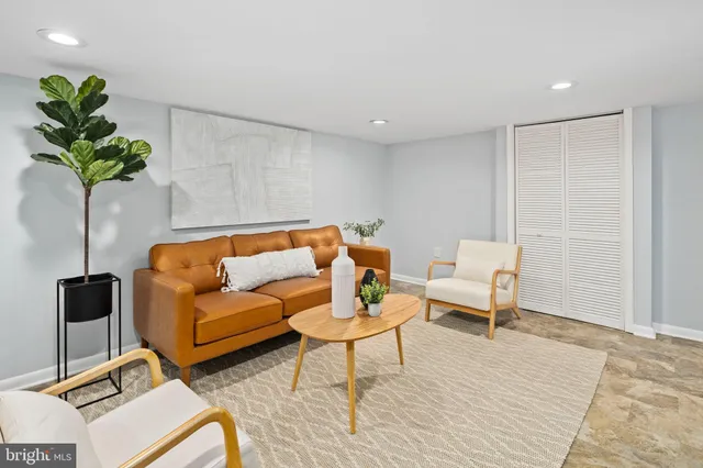 a living room with furniture and a potted plant