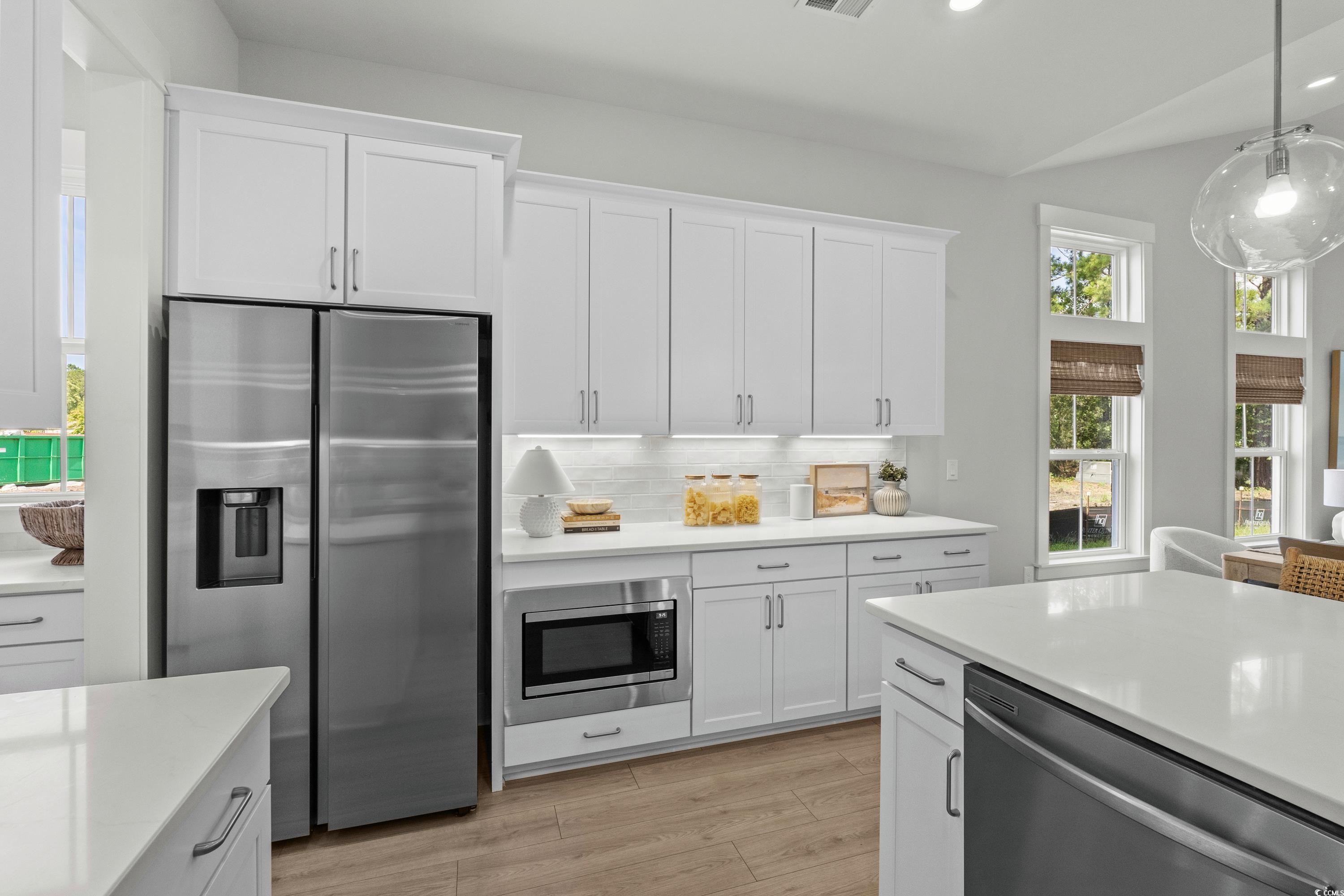 906 Foxtail Drive, Unit D44 Longs, SC 29568 - Photo 9 of 34 Kitchen featuring appliances with stainless steel finishes, tasteful backsplash, hanging light fixtures, wall chimney exhaust hood, and recessed lighting