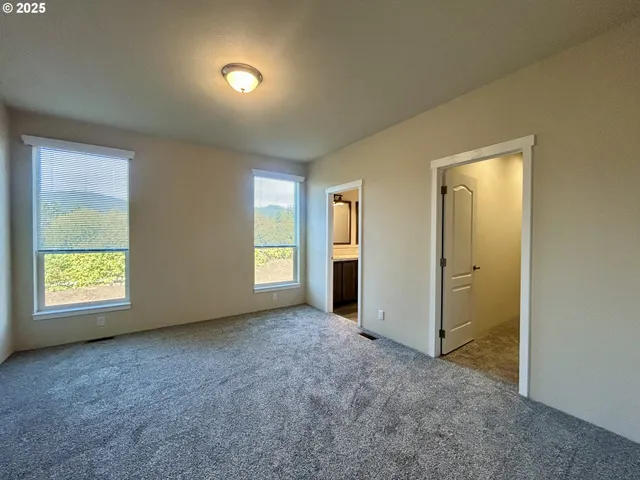 an empty room with windows and closet