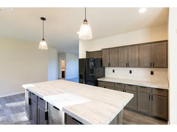 a kitchen with a counter space sink refrigerator and cabinets