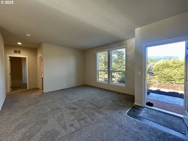 an empty room with windows lake and mountain view