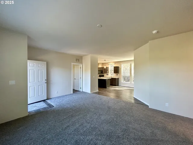 a view of empty room with a kitchen
