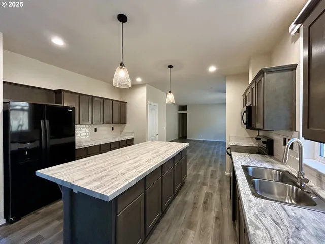 a kitchen with center island counter space a sink stainless steel appliances and cabinets