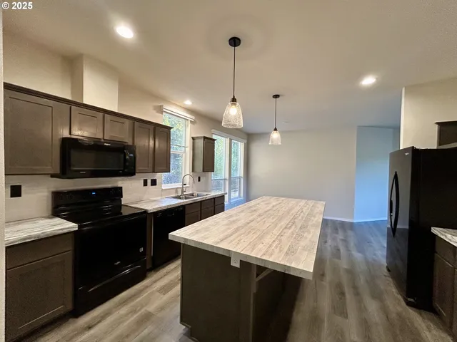 a kitchen with a sink refrigerator and microwave
