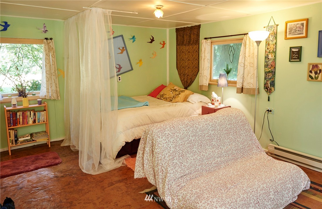 1505 East Roy Road Freeland, WA 98249 - Photo 4 of 13 a bedroom with a bed and wooden floor